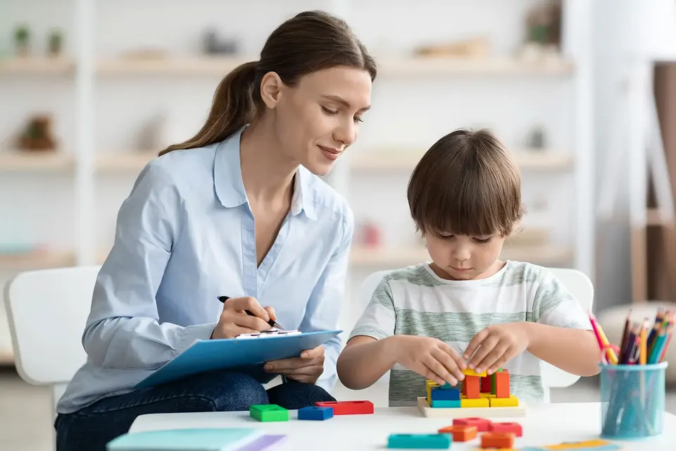 Therapist observing a young child during a developmental assessment